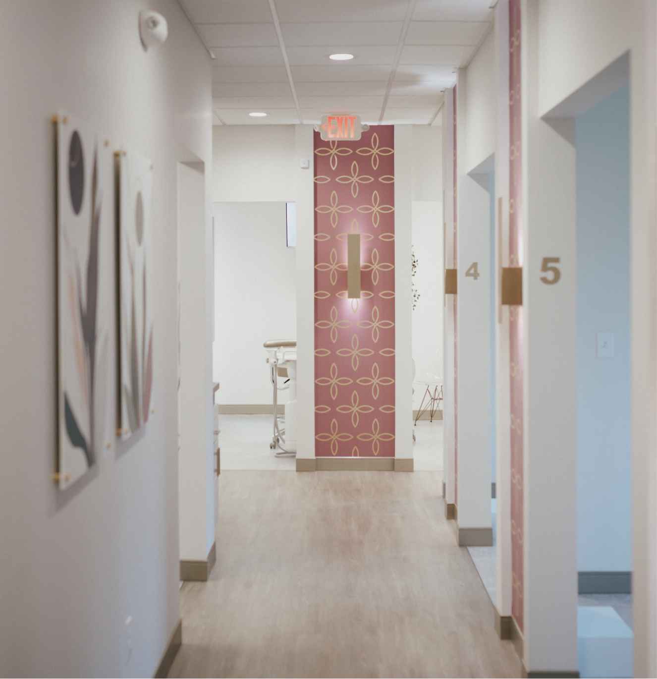 Modern dental office hallway with numbered treatment rooms and decorative wall art