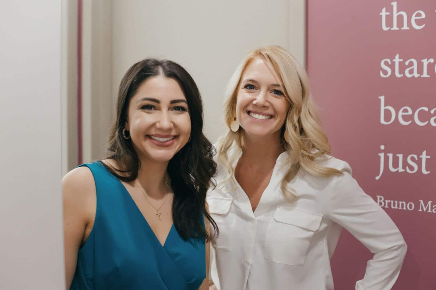 Two smiling women standing together in a dental office, representing a friendly and welcoming dental team.