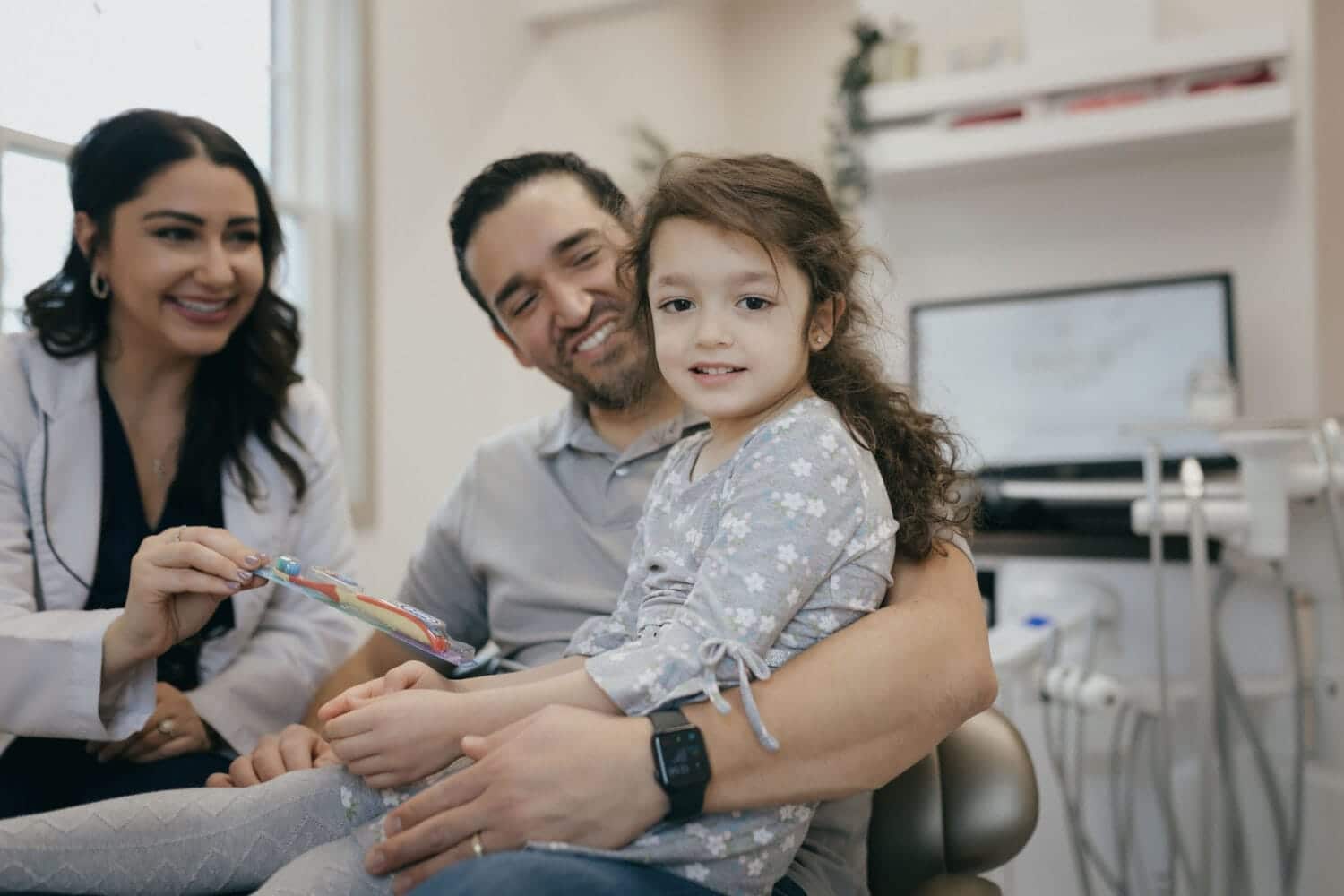 Dr. Josetta DeFrancisco with a young female patient and her father during a family dental visit